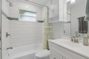 Ein Badezimmer mit Badewanne, Toilette und Duschbereich.