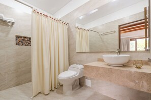 Un bany amb vàter, un lavabo, cortina de dutxa i un mirall.