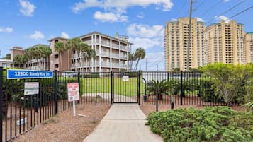 A gated residential area with a building labeled '13500 Sandy Key Dr.' and a 'No Trespassing' sign.