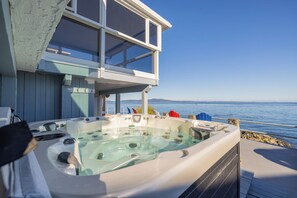 Un jacuzzi sur une terrasse avec vue sur la mer.
