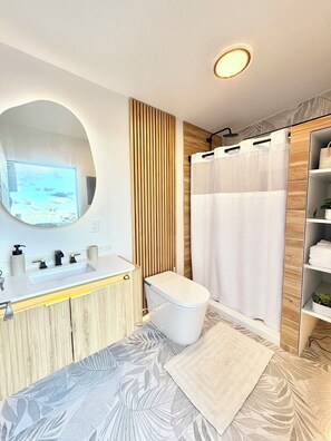 Une salle de bain moderne avec un meuble-lavabo en bois, des toilettes, un rideau de douche et un grand miroir.