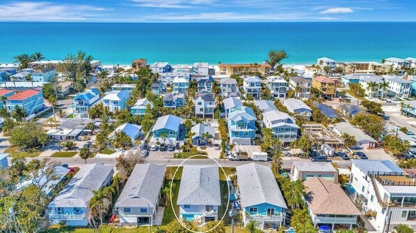 Una zona residenziale costiera con case disposte a file, vista libera sull'oceano e una strada che la percorre.