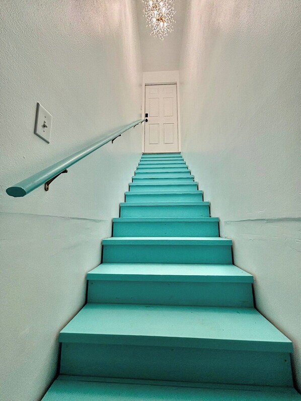 Eine Treppe mit Handlauf führt zu einer Tür.