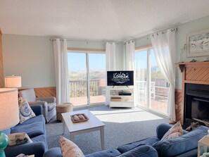 Ein Wohnzimmer mit einer Couch, einem Couchtisch, einem Flachbildfernseher und einem Kamin.