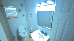 Un baño con inodoro, lavabo y espejo.