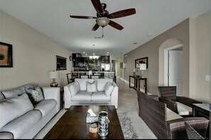A modern living room with a sofa, coffee table, and a ceiling fan.