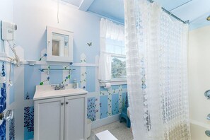 A bathroom with a sink, mirror, and window. - Weekapaug's Largest Rental — 7 Bedrooms, Sleeps 14, Steps to Everything (Westerly)