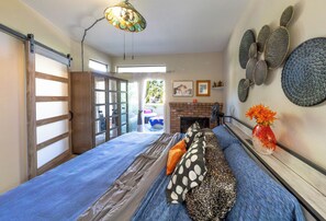 Une chambre à coucher avec un lit, une cheminée et une vue sur l’extérieur.