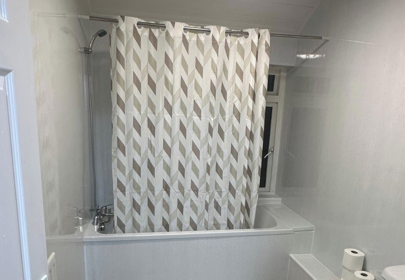 A bathroom with a shower, a toilet, and a sink.