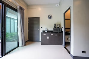 Een moderne keuken met een donker aanrecht, een magnetron en een waterkoker.