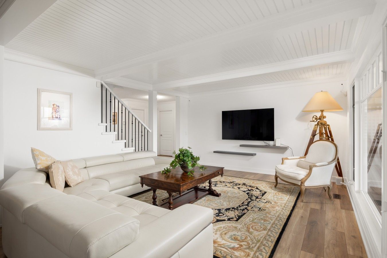 A living room with a sofa, coffee table, TV, and a lamp.