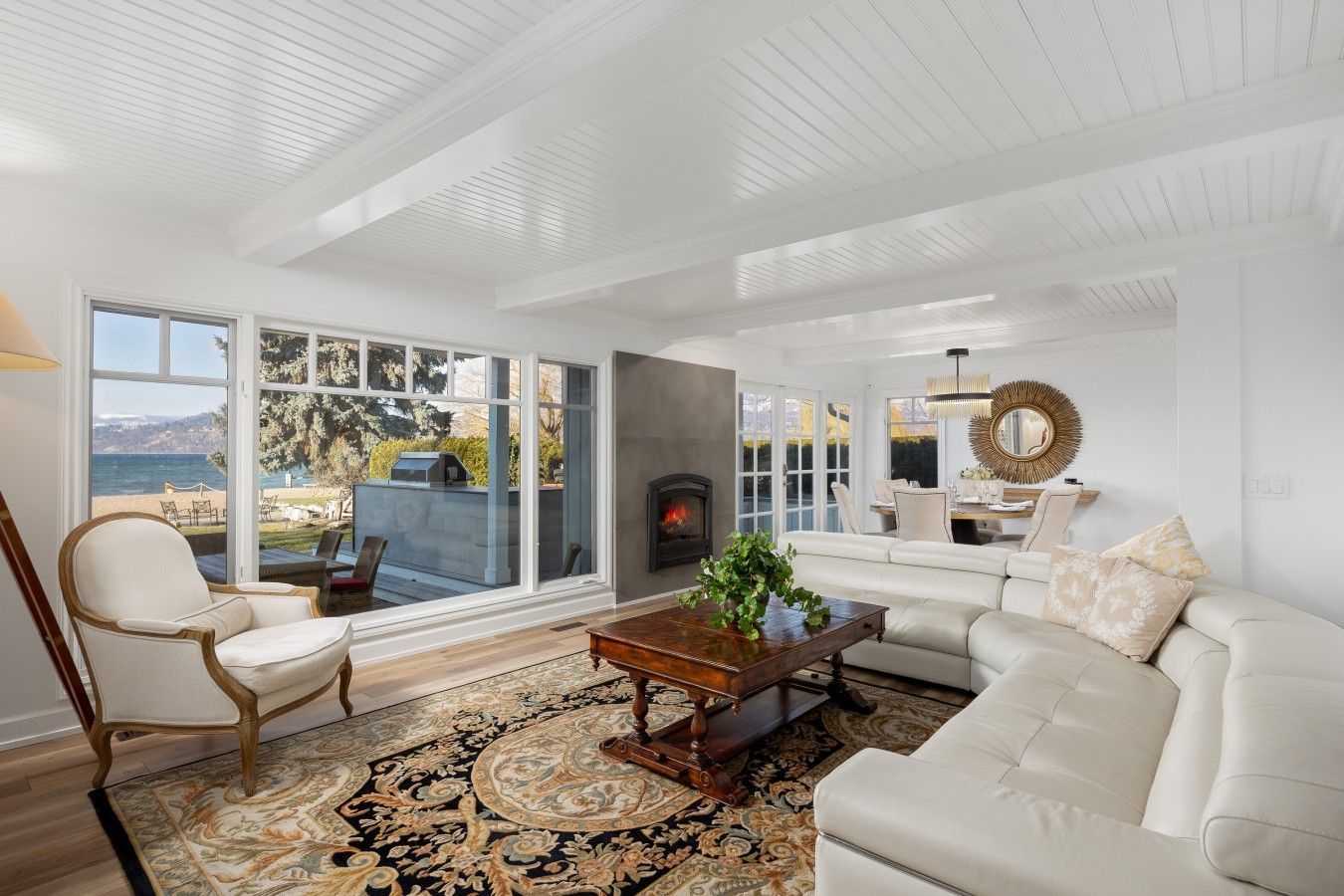 A spacious living room with a large window overlooking a scenic view, a fireplace, and a cozy seating area.