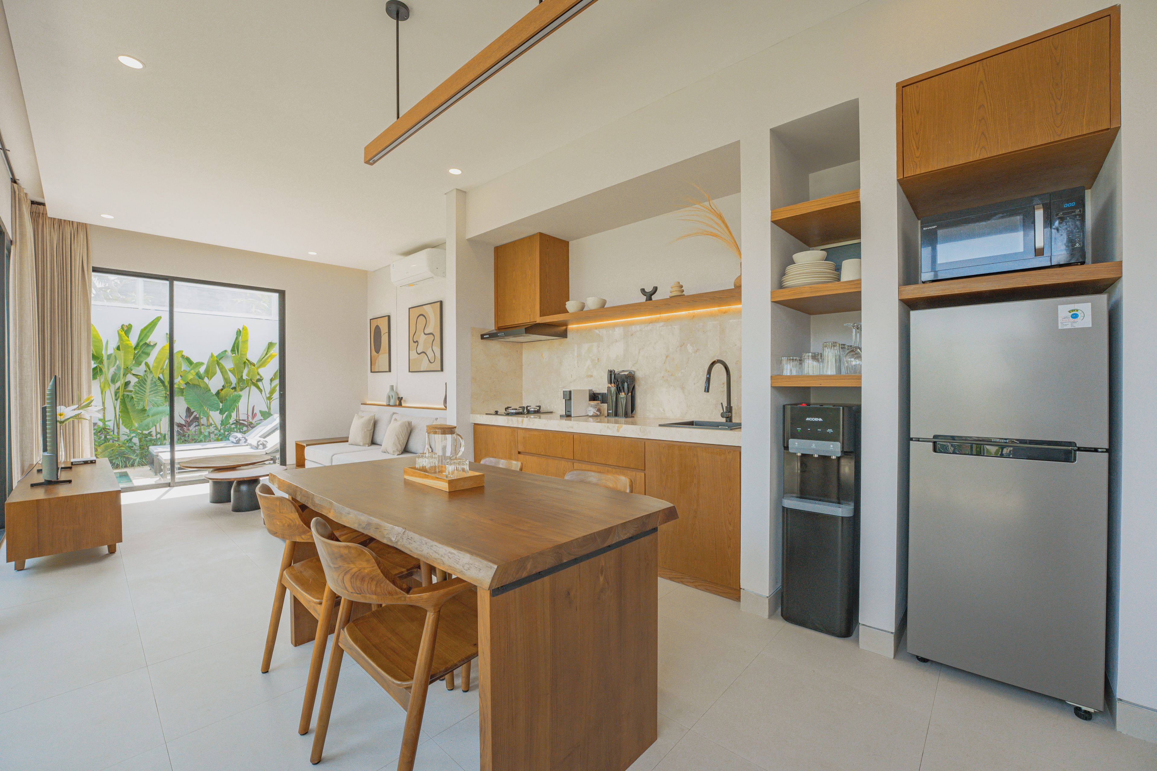 A modern kitchen with a central island, wooden cabinets, and stainless steel appliances.