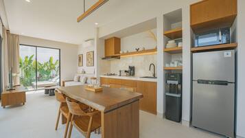 A modern kitchen with a central island, wooden cabinets, and stainless steel appliances.