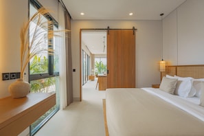 Habitación de hotel moderna con una cama grande, una mesita de noche, una ventana con cortinas y vistas al exterior.