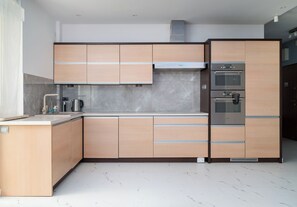Une cuisine moderne dotée d’appareils électroménagers intégrés, d’un pare-feu en marbre et d’un design épuré et minimaliste.