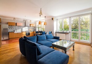Una cocina moderna con comedor, un sofá azul y ventanas amplias.