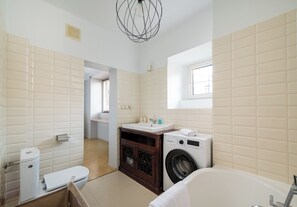 Un baño moderno con inodoro, lavamanos, lavadora y bañera.