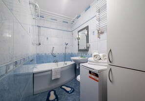 Un baño moderno con bañera, ducha, lavabo e inodoro.