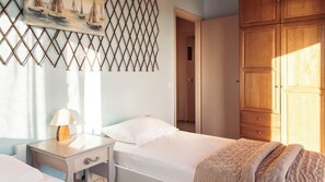 Un dormitorio con cama, mesita de noche, lámpara y armario.