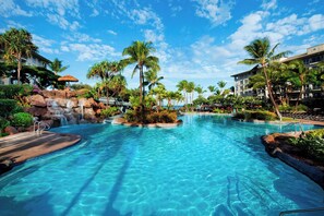 A large swimming pool with a waterfall feature, surrounded by palm trees and a resort building. - Westin Ka'anapali Ocean Resort Villas, 1 Bdrm Premium Oceanview Villa (Lahaina)