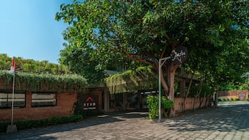 A paved pathway leading to a building with a sign that reads 'Jatu Photo.'