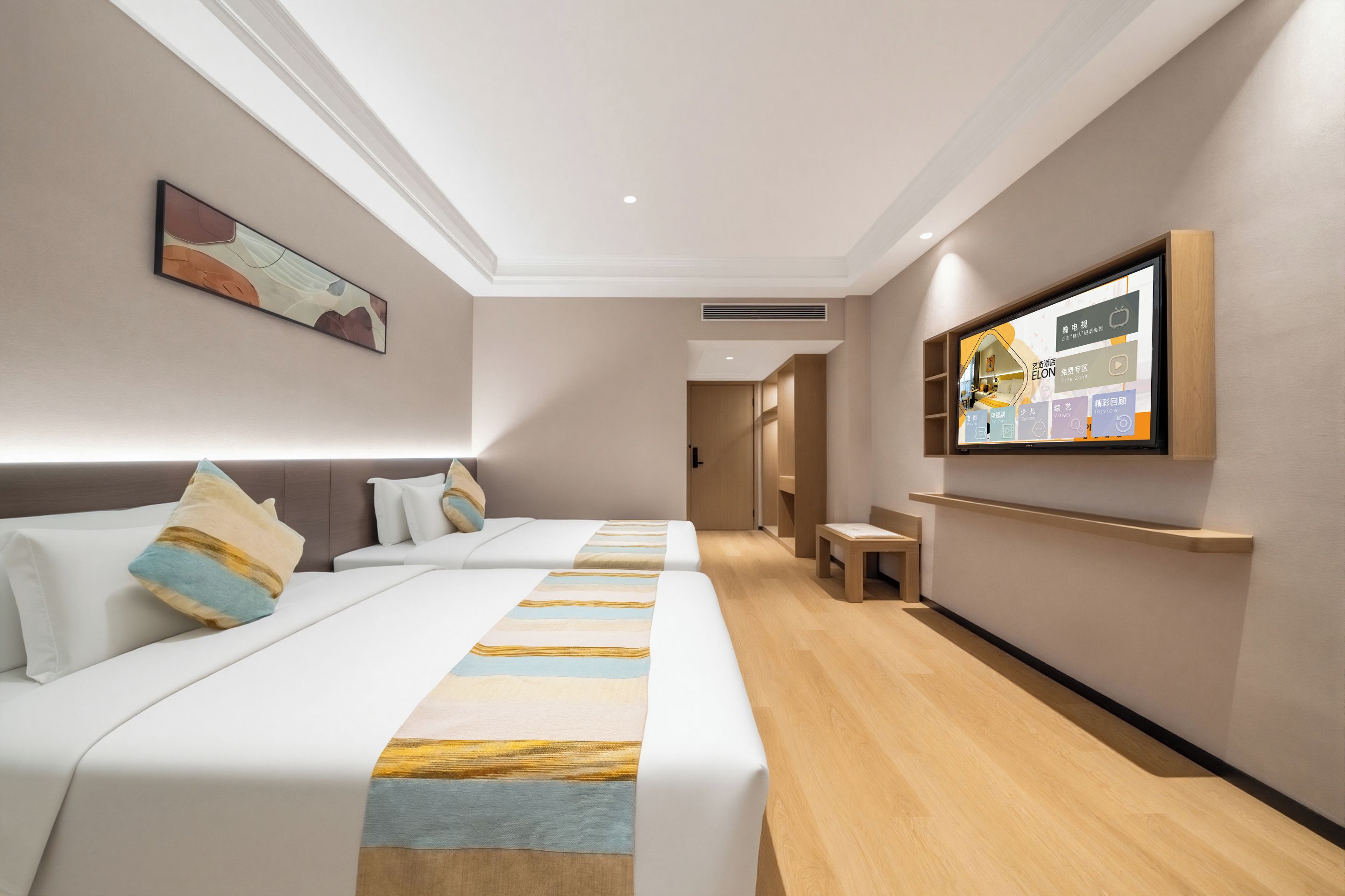 Una habitació d'hotel amb dos llits, una televisió i un quadre a la paret.