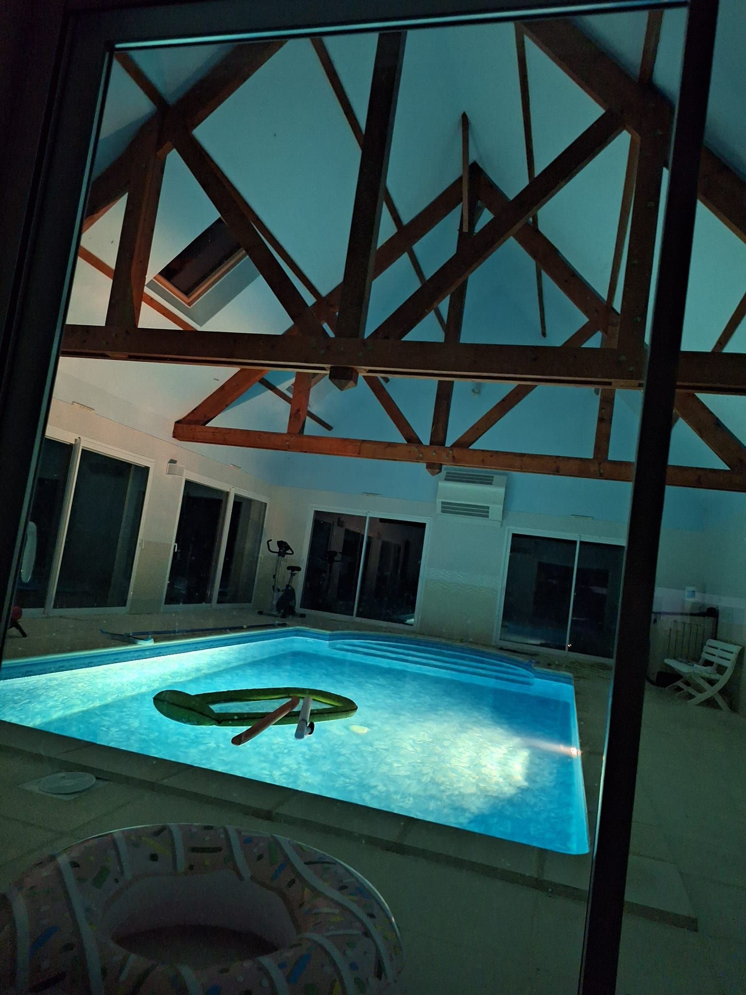 An indoor swimming pool with a view of the ceiling structure.