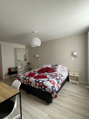 Una camera da letto con un letto, comodini, una scrivania e una sedia.
