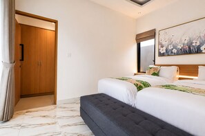 Ein Hotelzimmer mit Bett, einer Sitzbank, einem Kleiderschrank und einem Bild an der Wand.