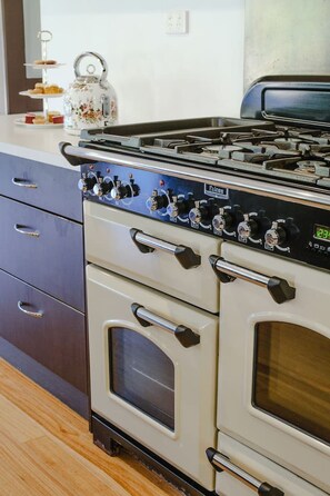 Una cucina con fornello, forno e un vassoio a tre piani sul bancone.