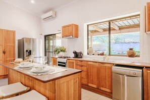 Una cucina moderna con mobili in legno, elettrodomestici in acciaio inossidabile e un'ampia finestra con vista.