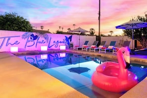 Ein Swimmingpool mit Liegestühlen und einem Flamingoboat.