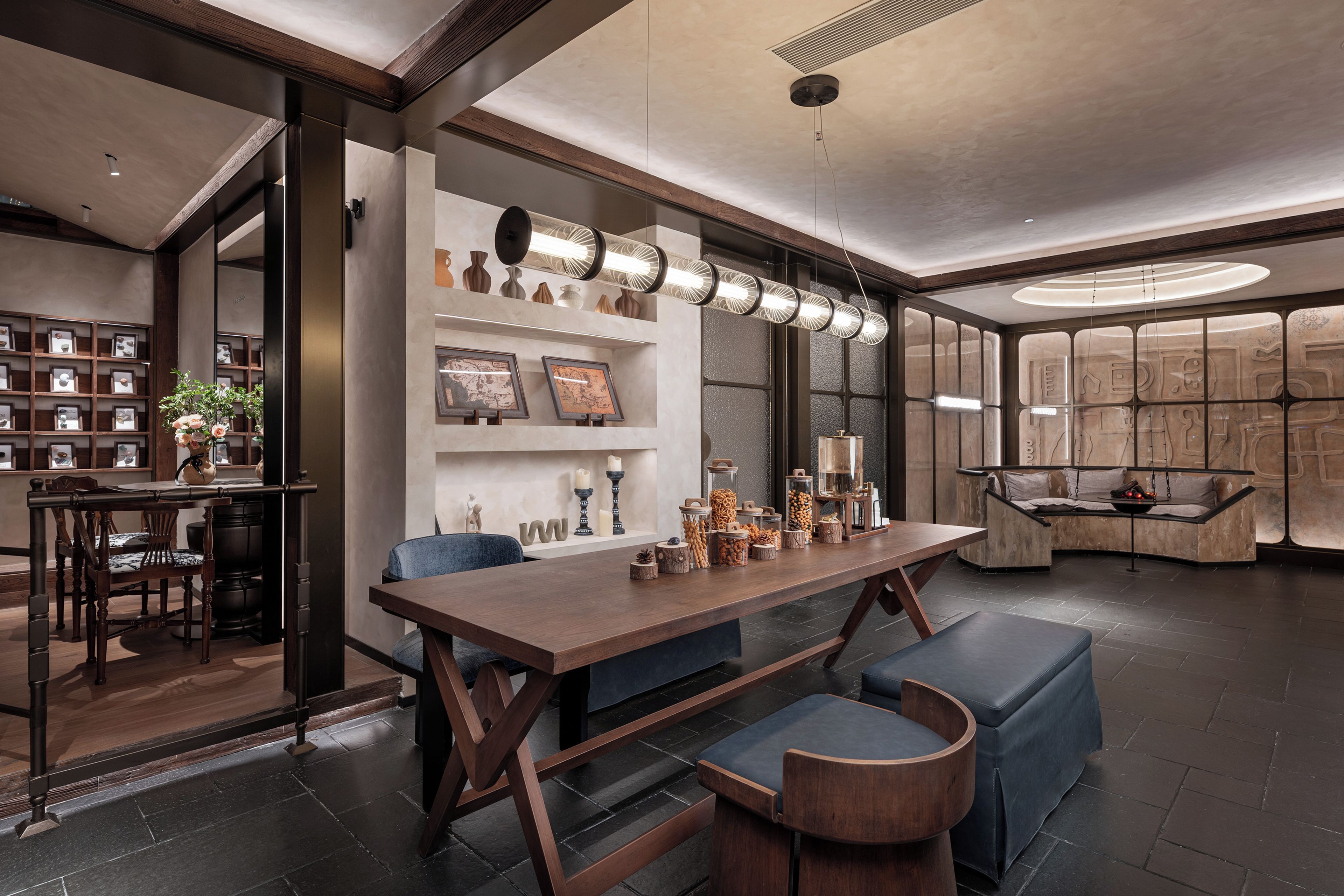 A modern interior with a dining area, a seating area with a swing, and a wall with decorative items.