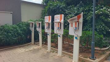 A row of electric vehicle charging stations with instructions to charge up with a Visa card.