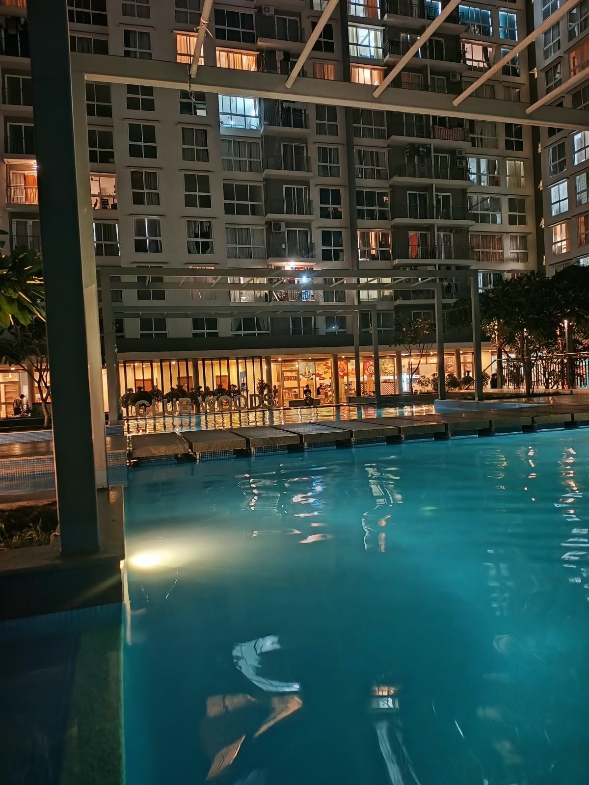 Et hotel med swimmingpool, flere etager og en restaurant.