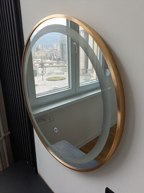 A round mirror with a gold frame on a wall. - STOUNE BRIDGE APARTMENT 24 (Skopje)