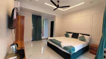 A modern bedroom with a bed, a ceiling fan, a coffee maker, and a sliding door leading to a balcony.