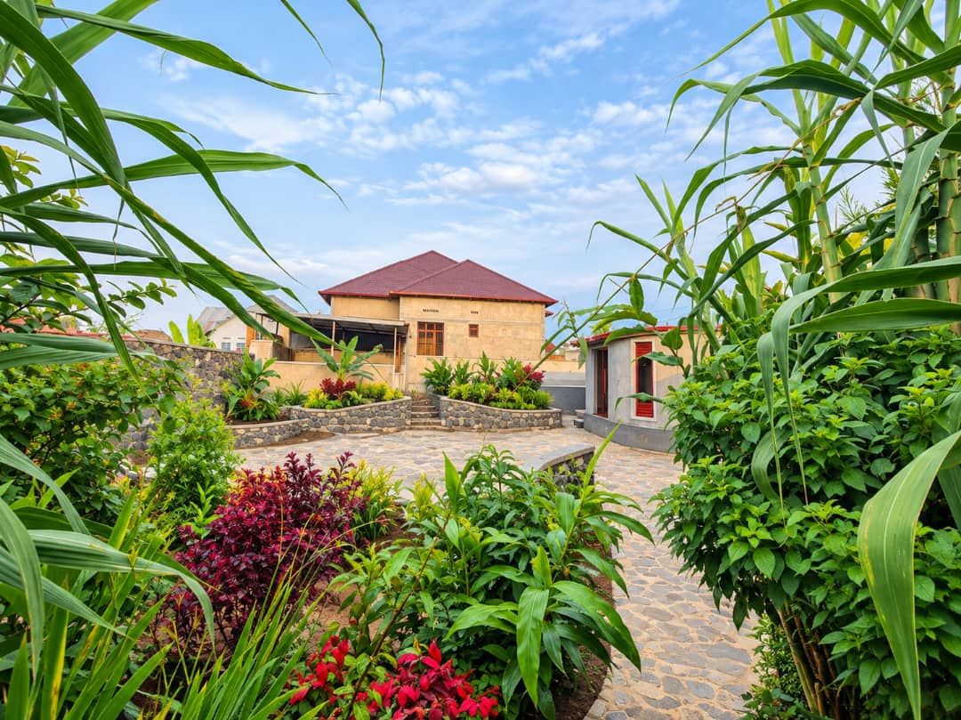 Une maison avec un toit rouge, entourée d’un jardin où poussent différentes plantes et bordée d’un chemin en pierre.