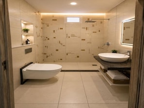 Une salle de bain moderne équipée de toilettes, d’un bidet et d’un lavabo.