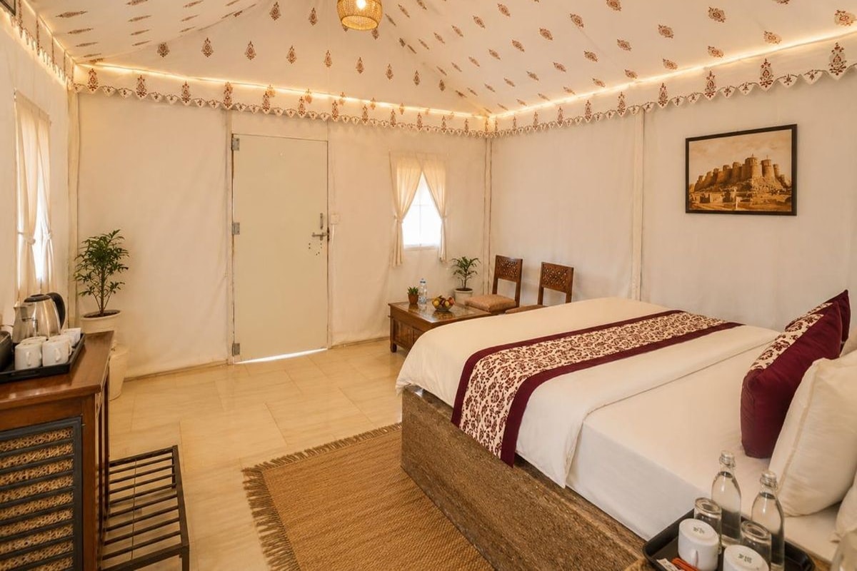 Une chambre d’hôtel avec un lit, une table de chevet, une lampe et un tableau au mur.