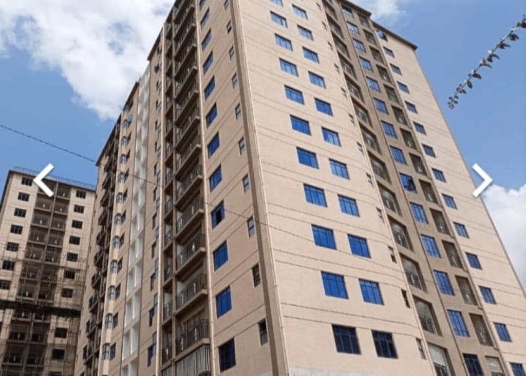 Ein mehrstöckiges Wohngebäude mit einheitlicher Fassade, zahlreichen Fenstern und Balkonen.