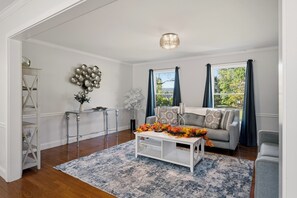 Sala de estar com sofá, mesa de centro e objetos decorativos.