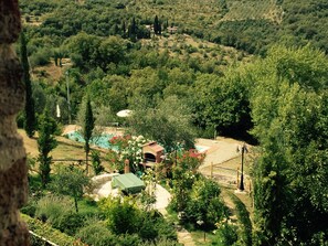 A lush garden with a swimming pool, a gazebo, and a variety of trees. - New Listing (Toscana)