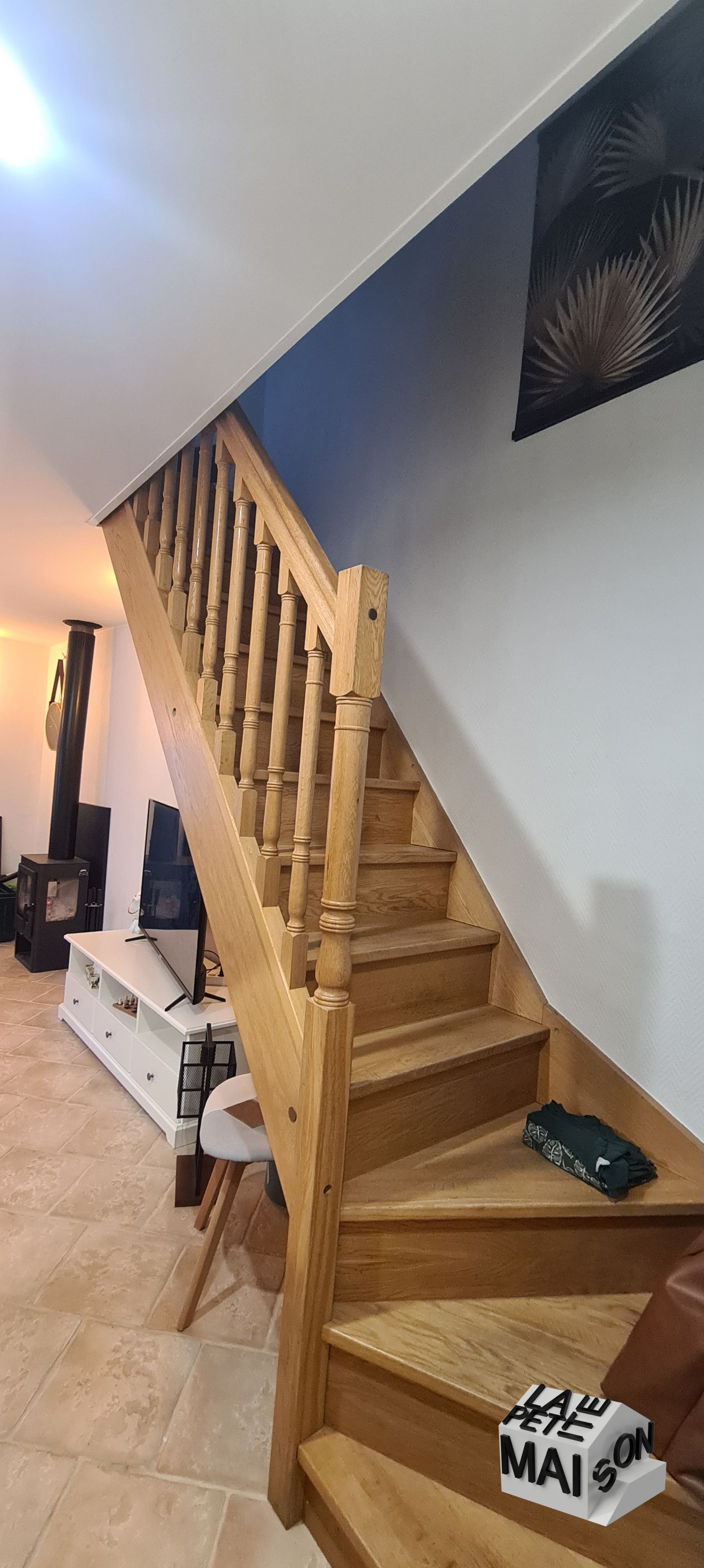 A wooden staircase with a handrail leading to a landing.