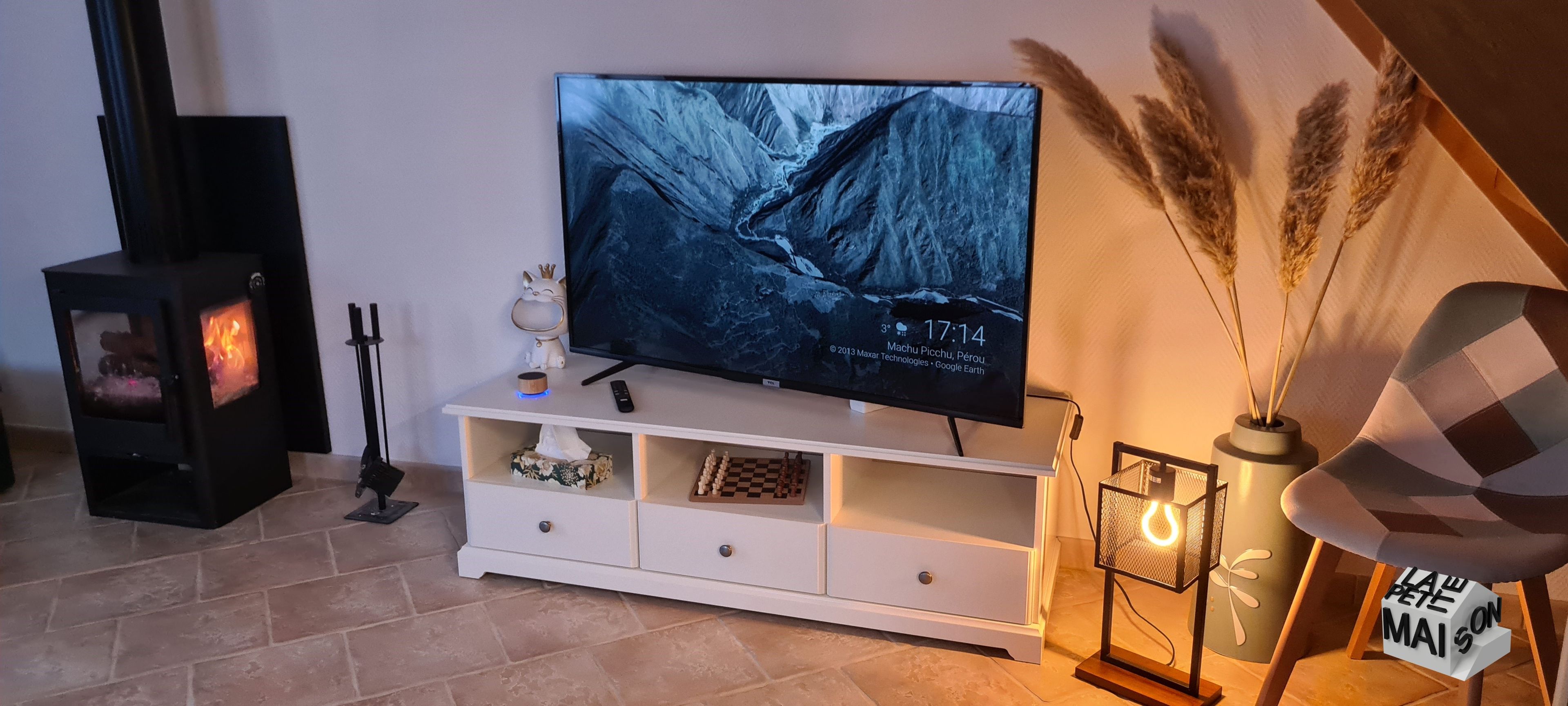 A living room with a television, a fireplace, and decorative items.