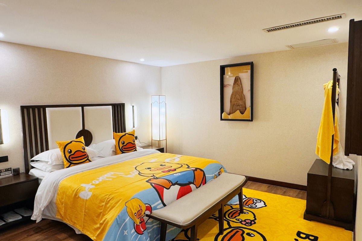 Une chambre d’hôtel avec un lit, une table de chevet, un lampadaire et un tableau encadré au mur.