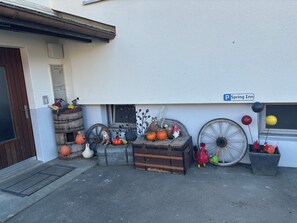 A building with a sign reading 'Spring Inn' and various outdoor decorations including pumpkins, a gnome, and a rooster. - New Listing (Schattenhalb)