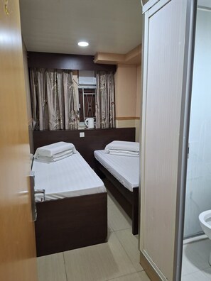 A hotel room with two beds, a shower area, and a view of the outside. - ME EASY HOSTEL (MongKok)