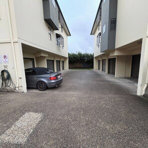 Eine schmale Auffahrt führt zu einem Gebäude, auf dem ein Auto geparkt ist.